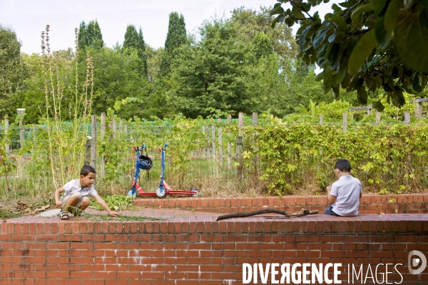Illustration Aout2016.Au parc de Bercy deux enfants assis sur un mur, jouent avec des branches.