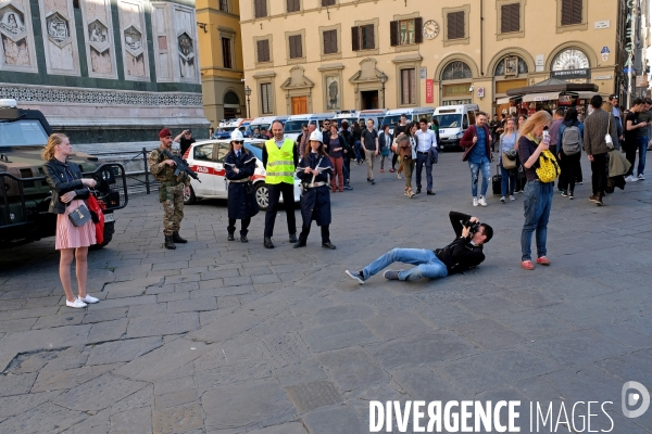 Florence.Place du duomo, un touriste se couche par terre pour portraiturer son amie