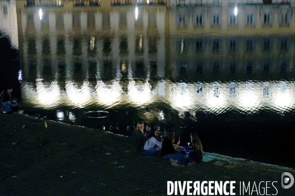 Florence.La nuit est tombee et les facades eclaireees se refletent dans le fleuve.Les copines sur une digue de l Arno
