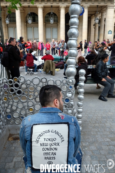 Illustration Mai2017.Place Colette, assis sur un banc,un homme  porte un blouson en jean avec cette inscription glorious gangsta Tokyo,New York, London,Milan,Paris.
