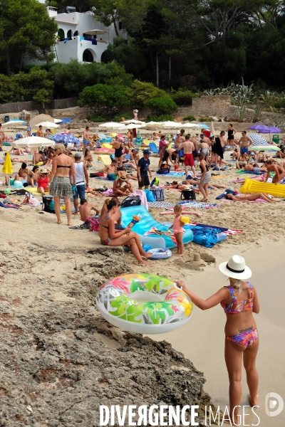 Vacances.Espagne.A la plage de Cala d Or, une femme en maillot de bain avec une bouee gonfable