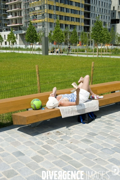 Illustration Juin 2014.Couchee sur un banc  une jeune fille lit au parc martin luther King