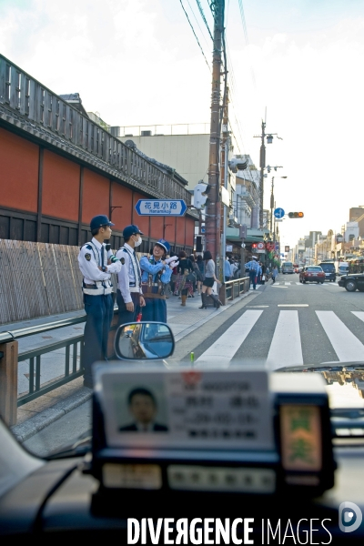 Kyoto.Vue de l interieur d un taxi, une femme policiere discute avec ses collegues masculins.