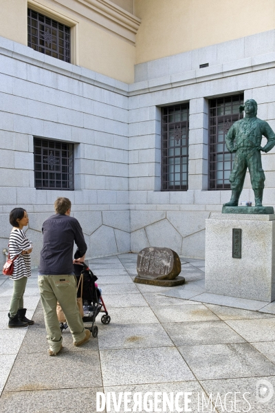 Tokyo.Musee militaire , le Yushukan.Un couple mixte avec un enfant dans une poussette devant la statue d un kamikaze