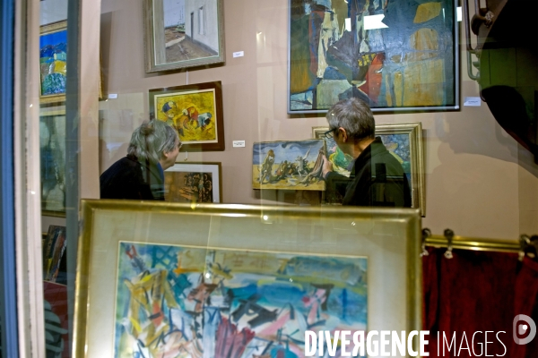 Illustration Décembre 2014.Dans une galerie,un marchand de tableaux propose une toile a un client
