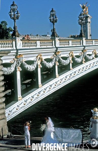 Des villes.Paris.Seance photo pour un ce couple de maries au pied du pont Alexandre 3