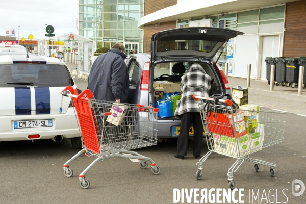 Illustration Fevrier2016.Sur le parking du supermarche , Auchan, un couple d anglais chargent leur voiture avec des caisses de vin