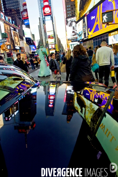 Retour a Manhattan # 01.Times Square, media city.Les enseignes lumineuses attirent la foule comme des papillons de nuit.Reflets des enseignes publicitaires  sur le capot d une grosse berline.