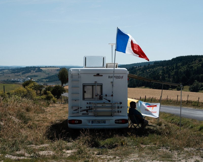 L'attente de l'arrivée Un supporter francais attend le passage du tour de france à l'abri du soleil sous le auvent de son camping car   