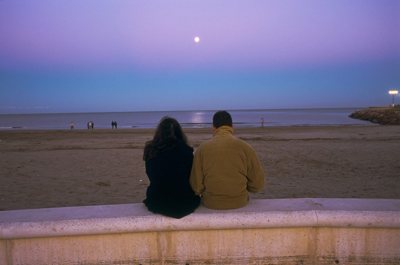Baisers Valencia : Plage de Malvarrosa. Les Valenciens aiment se detendre sur cette plage : un couple déjà adulte, en train de scruter l'horizon et la Lune qui monte au dessus de la mer.