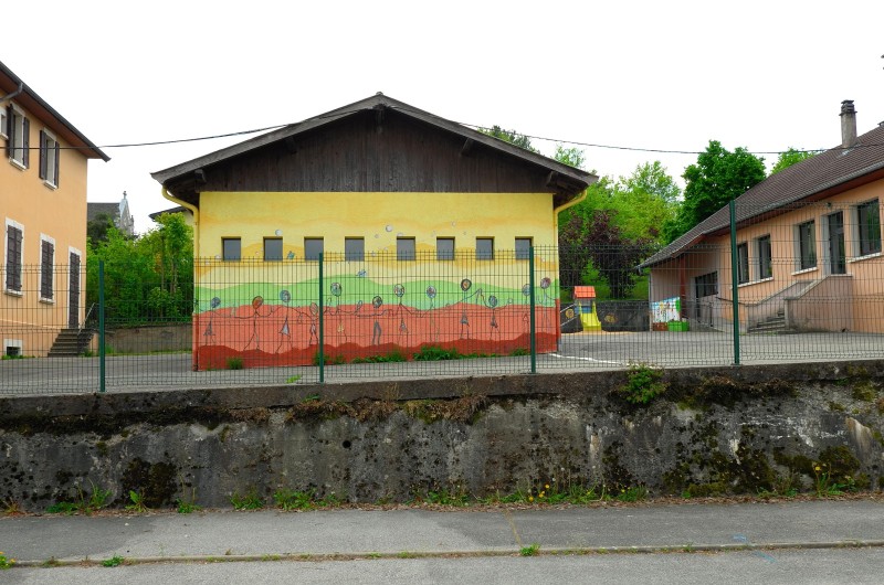 VIRUS : LUTTE ET CONSEQUENCES. LES ECOLES  Confinement en avril 2020 suite a la pandémie liée au Covid 19 , France   Ecole  primaire fermée en Haute Savoie  Cour de récréation vide et peinture sur les murs des bâtiments représentant des enfants se tenant par la main...