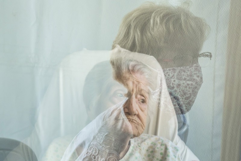 EHPAD - Les Visites Plexi - Quand l'attachement devient transparent EHPAD du centre hospitalier du Tonnerrrois. Visite Plexi pour Micheline, 93 ans, et sa fille qui lui a déjà rendu visite 3 fois depuis la mise en place de cette formule a la fin avril. Avant la crise du Covid-19, la fille de Micheline venait la voir tous les deux jours. Elles avaient l habitude de jouer aux dominos.      Dans les EHPAD, avec la crise sanitaire du covid-19, les visites des familles ont du etre reinventees pour respecter les gestes barrieres afin que le virus ne contamine pas les residents. blic du Centre hospitalier du Tonnerrois (Tonnerre, Yonne), les animatrices organisent les rendez-vous et les visites de visu aussi appelées « visites plexi » du fait de la paroi en plexiglas qui separe la personne agee de ses visiteurs.   Chaque visite est limitee a 30 minutes.   Paradoxalement, ce sont toutes ces mesures dites « barriere » qui, participant des circonstances sanitaires exceptionnelles que traverse le pays, renforcent les liens entre les differents protagonistes : residents, parents et soignants.   Mais la situation est parfois terrible quand, le temps de la visite, certains residents, du fait de leur pathologie, demeurent quasiment mutiques. Sans l'accompagnement et les reassurances de l animatrice ou de l animateur, ce moment semble parfois bien long et le silence profond.  Les regards se croisent ou s evitent, les yeux se brouillent. Il est decidement loin le temps ou les gestes d affection - une main posee sur celle de l etre cher, une caresse sur le visage - tentaient d adoucir la separation de la vie en institution. Depuis trois mois maintenant, il faut toujours continuer a s aimer mais sans se toucher. .