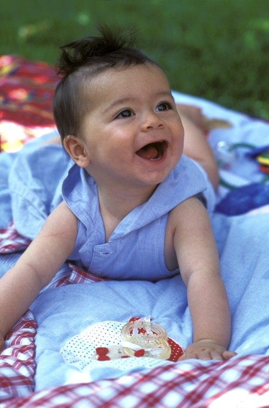 bébé, portraits Bébé 6 mois dans le jardin qui redresse sa tête en riant, sur le ventre. Baby straightens his head, laughing, on the belly.