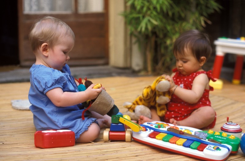 modes de garde, crèche, halte garderie Garde partagée, deux bébés jouent tranquillement. Nursery, two babies play quietly.