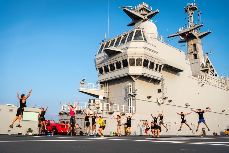 Reportage : « Sport en pleine mer » Les marins du DIXMUDE participent à une séance de sport en extérieur le 7 juin2018 en pleine mer de Chine méridionale sur l'énorme pont d'envol de 5000m2. Partis depuis 3 jours du Vietnam, l'activité aéronavale de la semaine a empêché toute pratique du sport en extérieure. En ce jeudi soir les hélicoptères anglais de type wildcat sont rangés, et les marins peuvent  profiter d'une animation sportive proposée par Pierre, moniteur EPMS. La lumière de fin de journée est magnifique et la température plus acceptable. A bord du Batiment de projection et de Commandement Dixmude, 2eme plus important navire de la marine nationale francaise apres le porte-avions Charles de Gaulle, pendant la mission Jeanne D'Arc lors d'une traversee en mer Chine Méridionale entre Saigon et Singapour, SINGAPOUR - 07/06/2018.