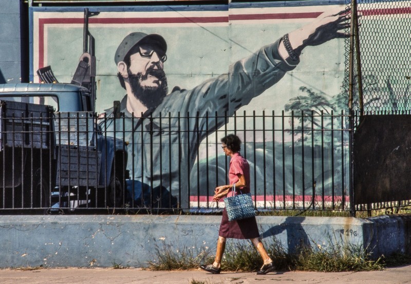 CUBA si ! Passant cubain devant une affiche de propagande pour Fidel et la révolution cubaine à la Havane .