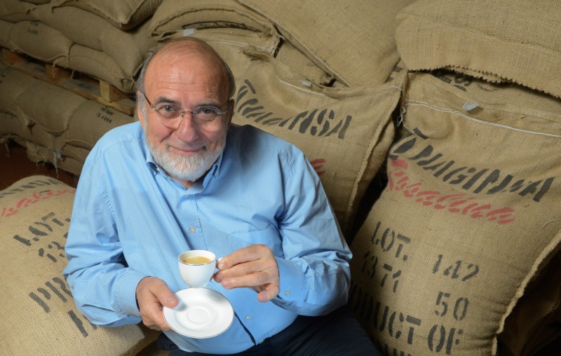 Instants Eco (Portraits - Entreprises) Portrait de Jean-Pierre Blanc, PDG des Cafés Malongo qui pose avec une tasse de café, assis sur des sacsde café