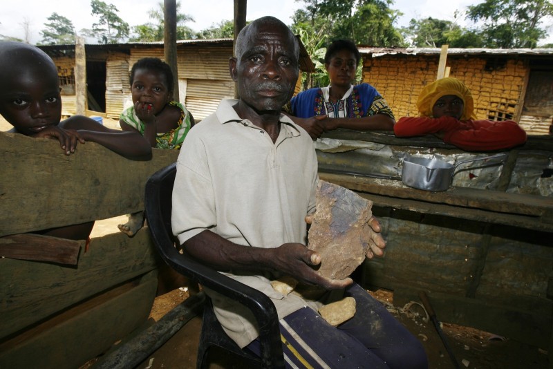 Gabon, pour le fer de Belinga-Avril 2008 2008 April -Gabon. Environnement-Economie- Chine-Afrique. Village de Mayibout, Papa Nestor tient dans ses mains le precieux minerais que les chinois vont bientét exploiter dans les Monts de Belinga. Lsazy@divergence-images.com  -  (33) 0616286963