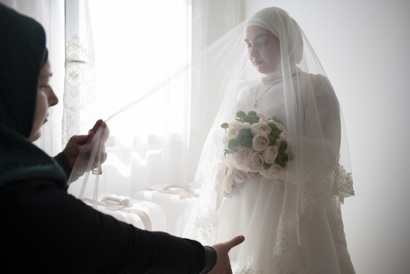 Le mariage tchétchène Une femme tchétchène ajuste le voile de Zaourbek le jour de son mariage dans l'appartement de ses parents. Nice le 25 mars 2022. 