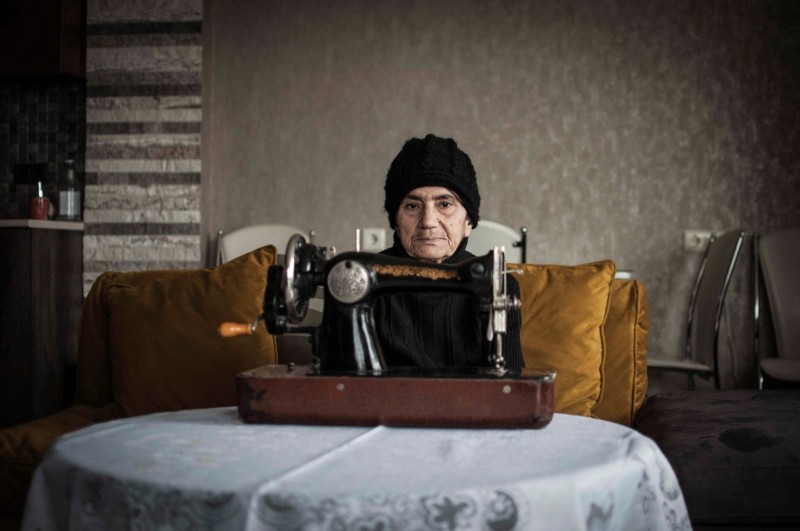 Femmes de Géorgie, tradition et modernité Lamara, ancienne couturiere georgienne, pose avec sa machine a coudre dans la maison de ses enfants a Tbilissi. La maison est bien chauffee, mais Lamara, a son habitude, garde son bonnet.