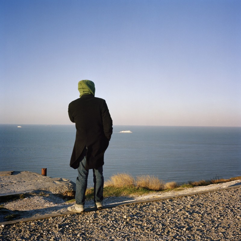 Détroits, portes maritimes de l'Europe. Migrant au Cap Blanc, dans le détroit du pas-de-calais, regardant les ferrys à l'approche de Calais.