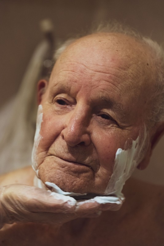 Des Attentions Soins précis et méticuleux de rasage effectués par une aide soignante pour le résident d'un ehpad