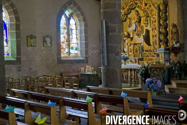 Bretagne.L interieur d une eglise avec des petits bateaux de couleur sur les bancs