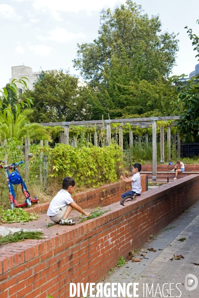 Illustration Aout2016.Au parc de Bercy deux enfants assis sur un mur, jouent avec des branches.