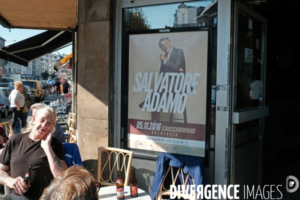 Anvers.A la terrasse d un cafe un homme boit une biere sous l oeil de Salvatore Adamo qui se produit en ville