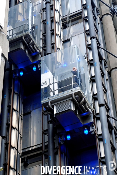 Londres.Un homme dans l un des ascenceurs exteieurs de la Lloyd s building