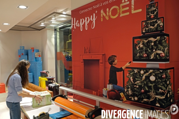 Illustration Decembre2016.Etudiante confectionnant les colis de Noel  pour unr organisation caritative dans un magasin d  electromenager