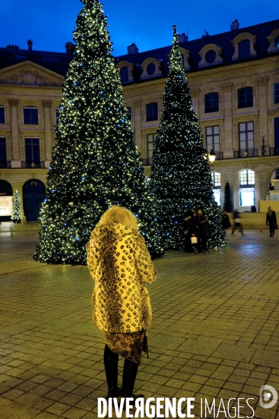 Illustration Decembre2016.Place Vendome, devant les sapins de Noel, une femme en manteau de fourrure
