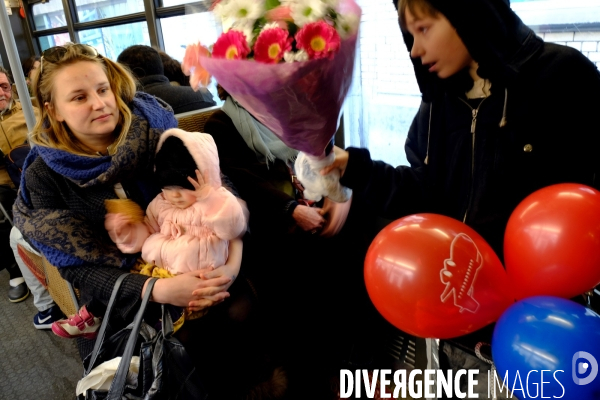 Bruxelles.Dans le tramway,une mere de famille avec ses enfants,un bouquet de fleurs et des ballons gonfables.