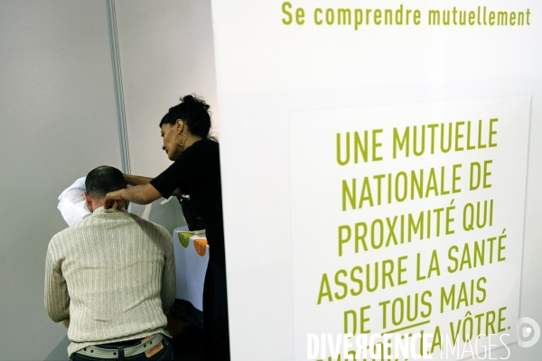 Salon des entrepreneurs.Eovi Mcd  mutuelle sante interprofessionnelle.Une ostheopathe masse un visiteur