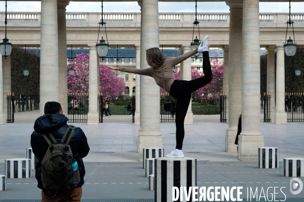 Illustration Mars2017.Au Palais Royal une jeune fille fait des etirements  sur  les colonnes de Buren