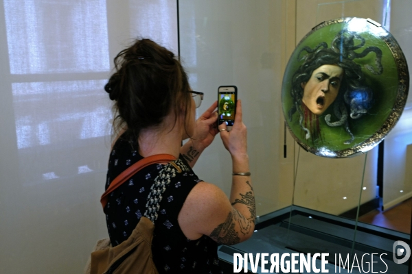 Florence.A la galerie des Offices, une jeune femme prend en photo avec son smartphone, une  tete de meduse peinte par le Caravage