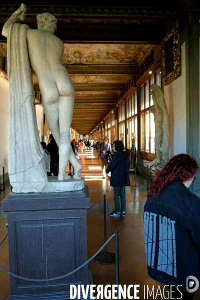 Florence.Au pied d une statue dans la galerie des Offices, une fille porte une veste avec cette inscription : get lost