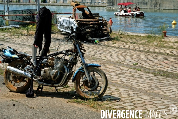 Un ete le long du canal de l Ourcq.Restes calcines dune moto et d une voiture sur la berge