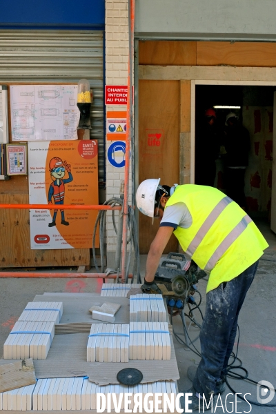 Juillet2017.Sur un chantier de construction,un ouvrier decoupe des carreaux de faience