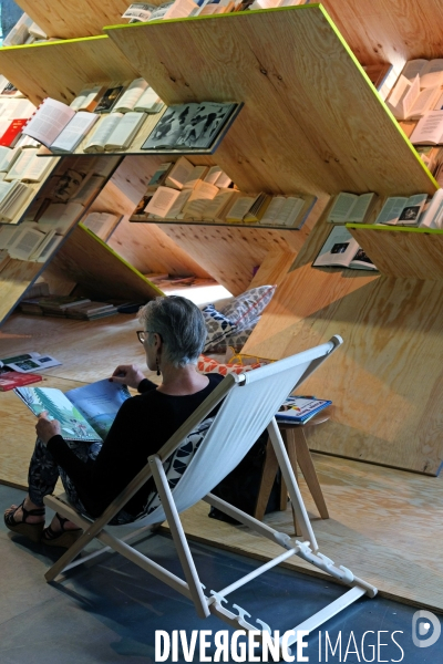 Juillet2017.Une femme lit une bande dessinnee assise dans un transat