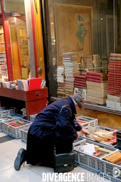 Au passage Verdeau,un homme choisit un livre d occasion dans des casiers poses a terre