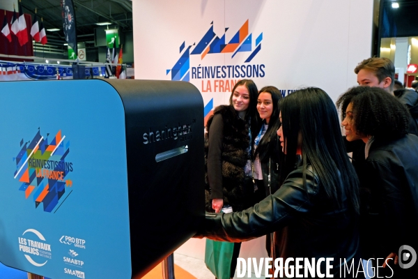 Au salon des maires de France, sur le stand de la FNTP, des jeunes femmes font des selfies