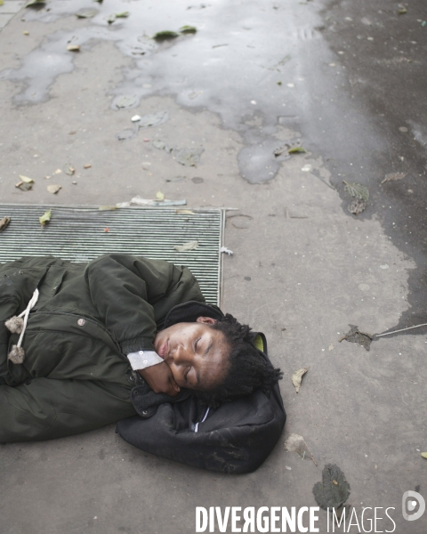Jeune femme endormie sur une bouche d air chaud, Paris Nord
