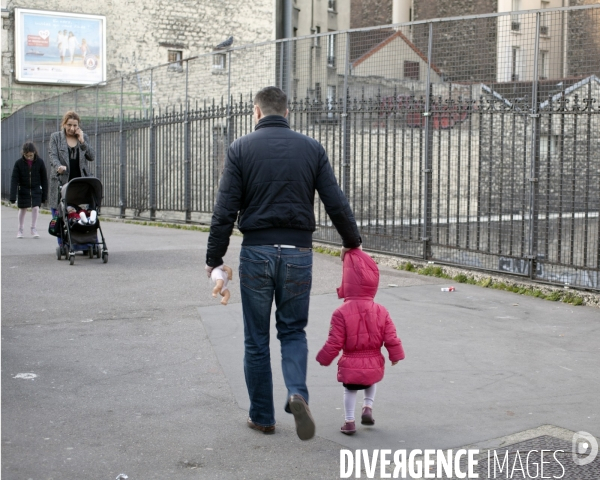 Homme tenant un enfant par la capuche de son manteau.