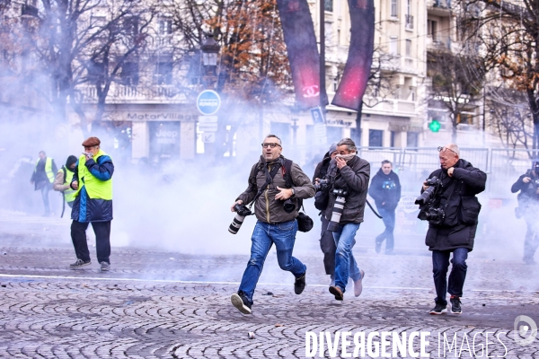 Les photographes refluent devant les lacrymognes lors de la Manifestation Gilets Jaunes sur les Champs Elysees 24 novembre 2018