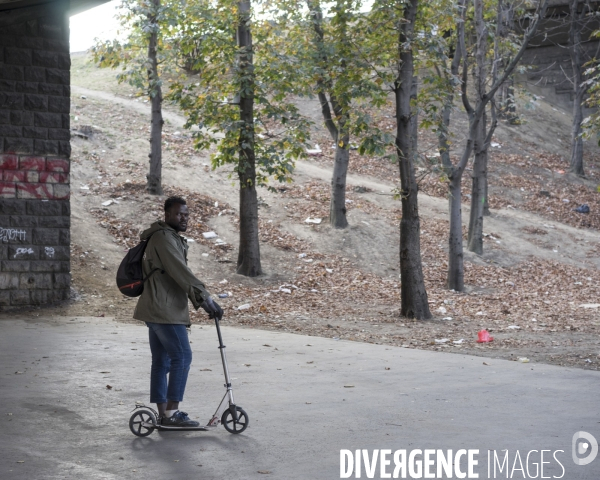 Homme sur une trottinette, porte de la Chapelle