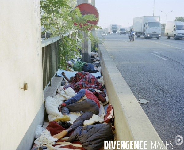 Réfugiés couchés sur le bas coté de l autoroute A1 Paris