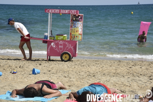 Travail saisonnier. Jeune marchand ambulant de confiseries, sur la plage