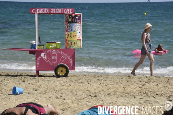 Travail saisonnier. Jeune marchand ambulant de confiseries, sur la plage