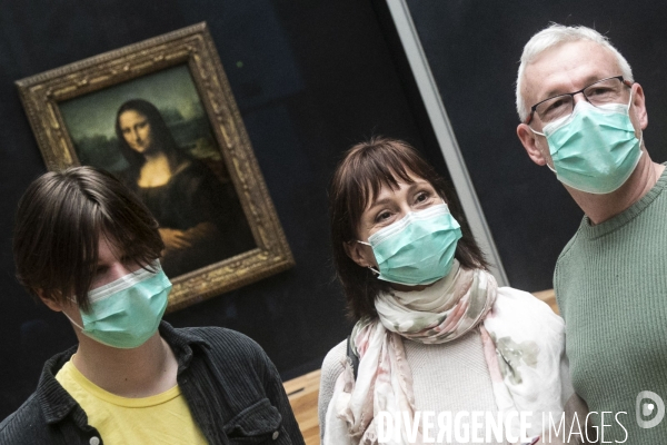 Les visiteurs du musée du Louvre se protègent du Covid-19.